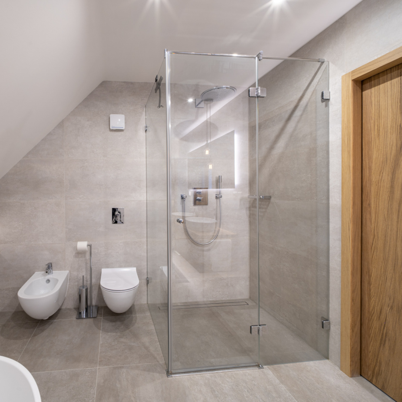 Moderní skleněný sprchový kout v podkrovní koupelně