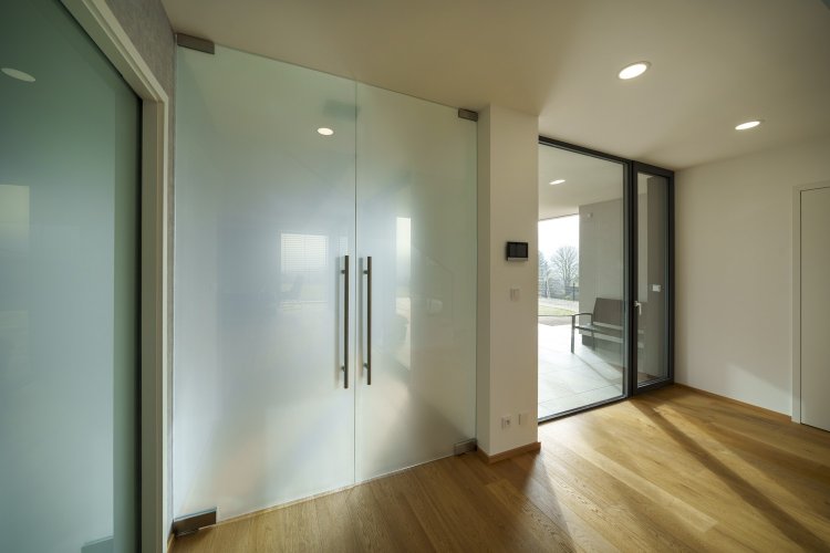 Otočné skleněné dveře v moderním interiéru